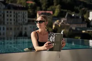 Una donna legge un libro in piscina.