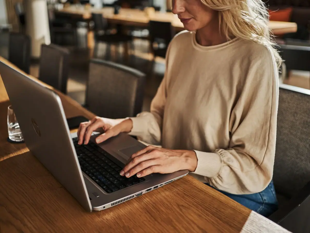 Donna seduta a un tavolo che utilizza un laptop.