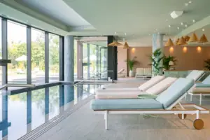 Una piscina con sedie a sdraio in primo piano e un’altra piscina sullo sfondo.