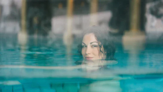 Donna che nuota in una piscina all'aperto.