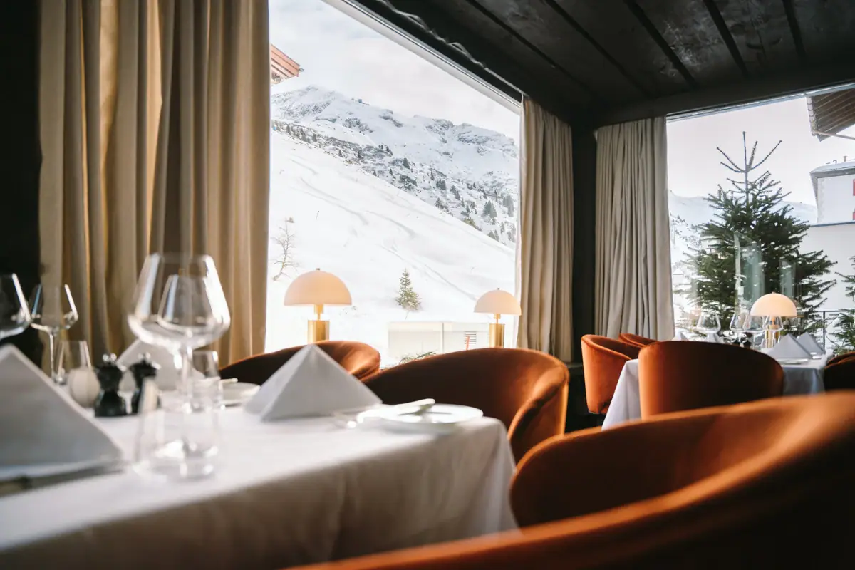 Restaurant Ein Restaurant mit Blick auf die Berge durch große Fenster.
