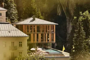 Edificio con piscina al centro, circondato da alberi e piante.