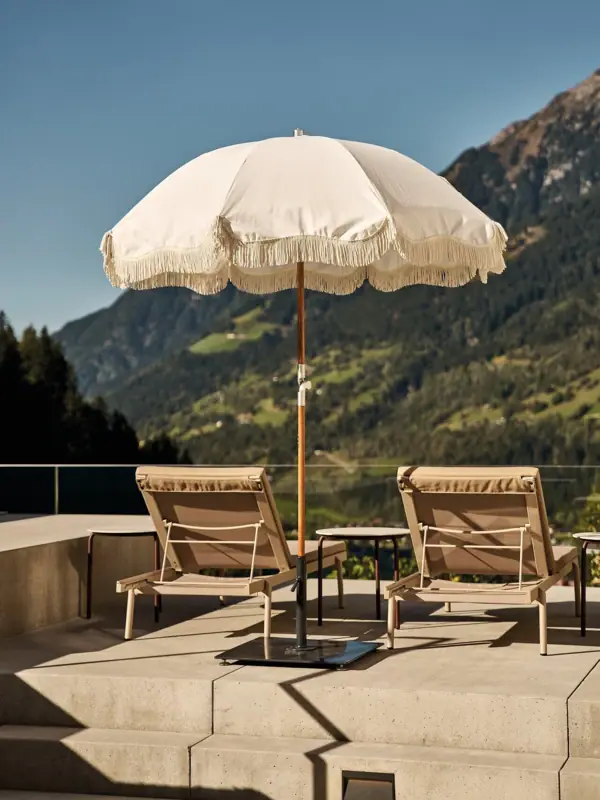 Ombrelloni e sedie bianche su una terrazza.