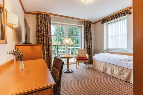 Stanza d'hotel con letto e scrivania, arredamento moderno.