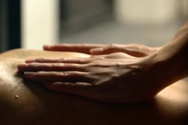 Eine Hand auf einem Rücken.