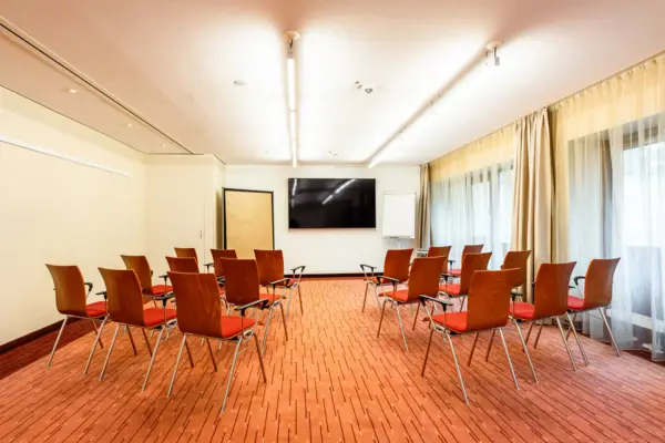 Una sala con sedie e uno schermo all’A-ROSA Travemünde.