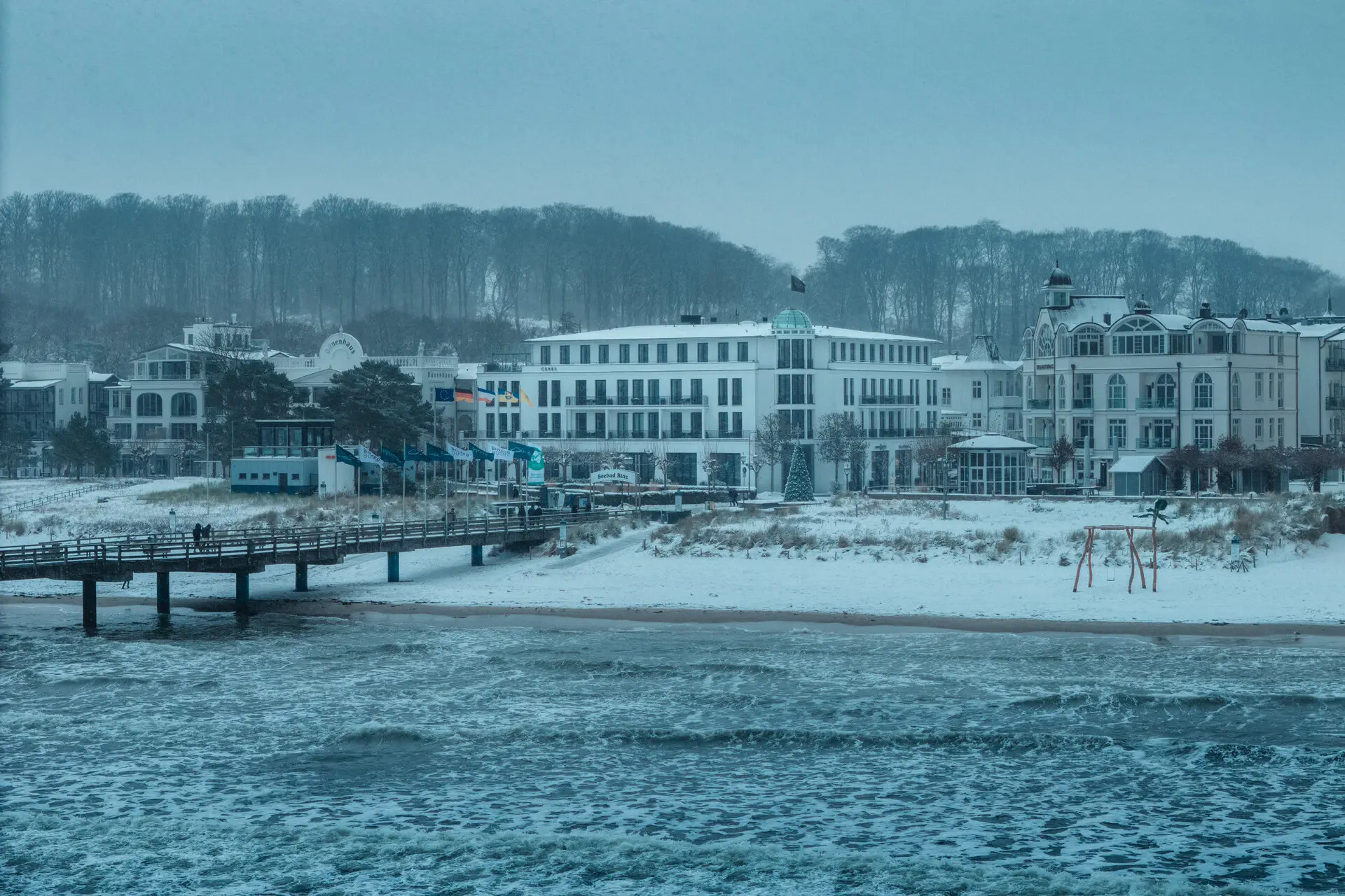 A-ROSA Ceres sul mare Spiaggia innevata con edifici in inverno.