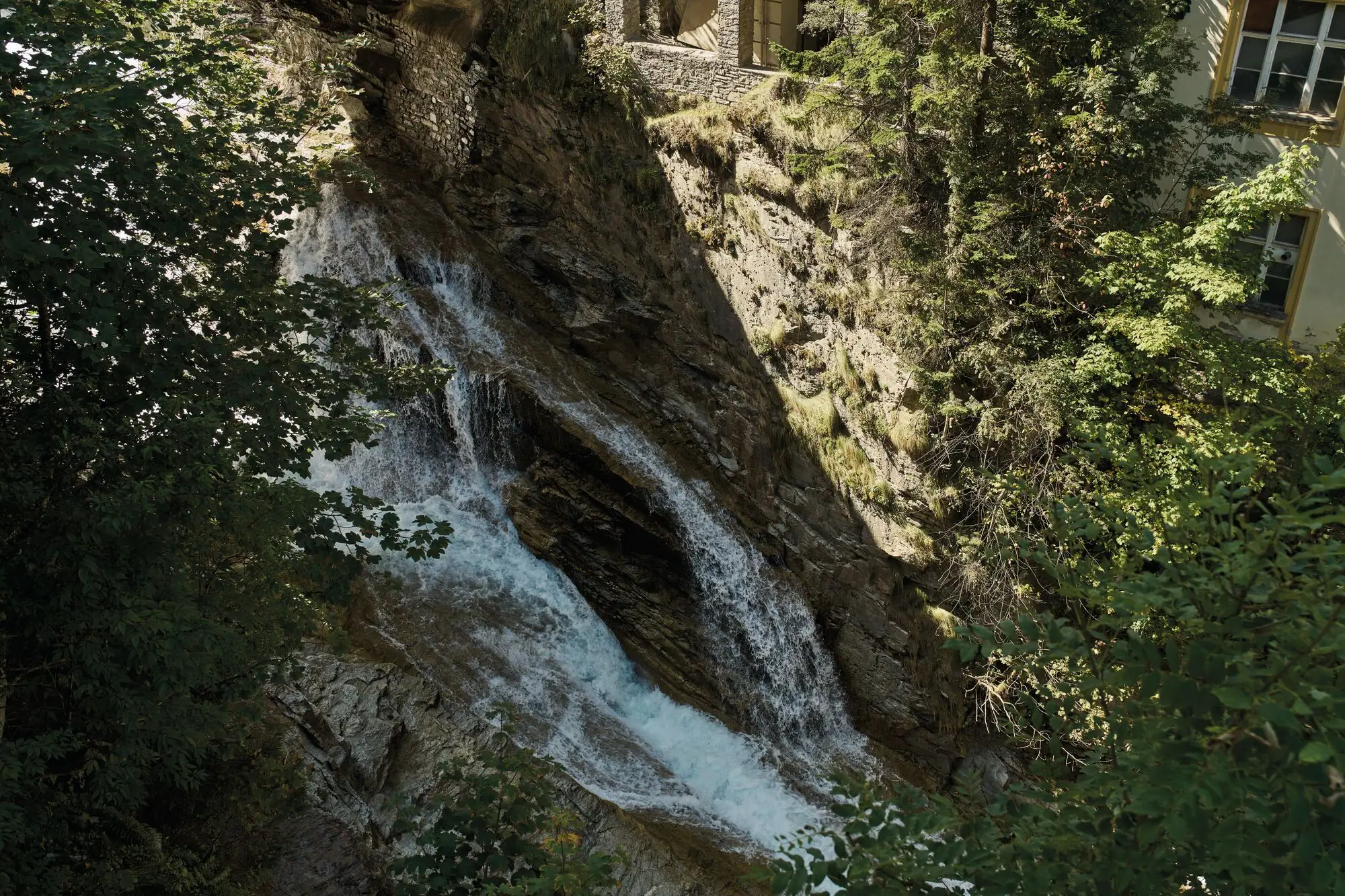 Cascata su una scogliera con alberi circostanti.