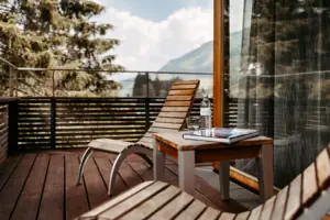 Sedia e tavolo su una terrazza in legno all’aperto.