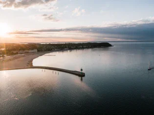 Lungo pontile su un lago al tramonto.