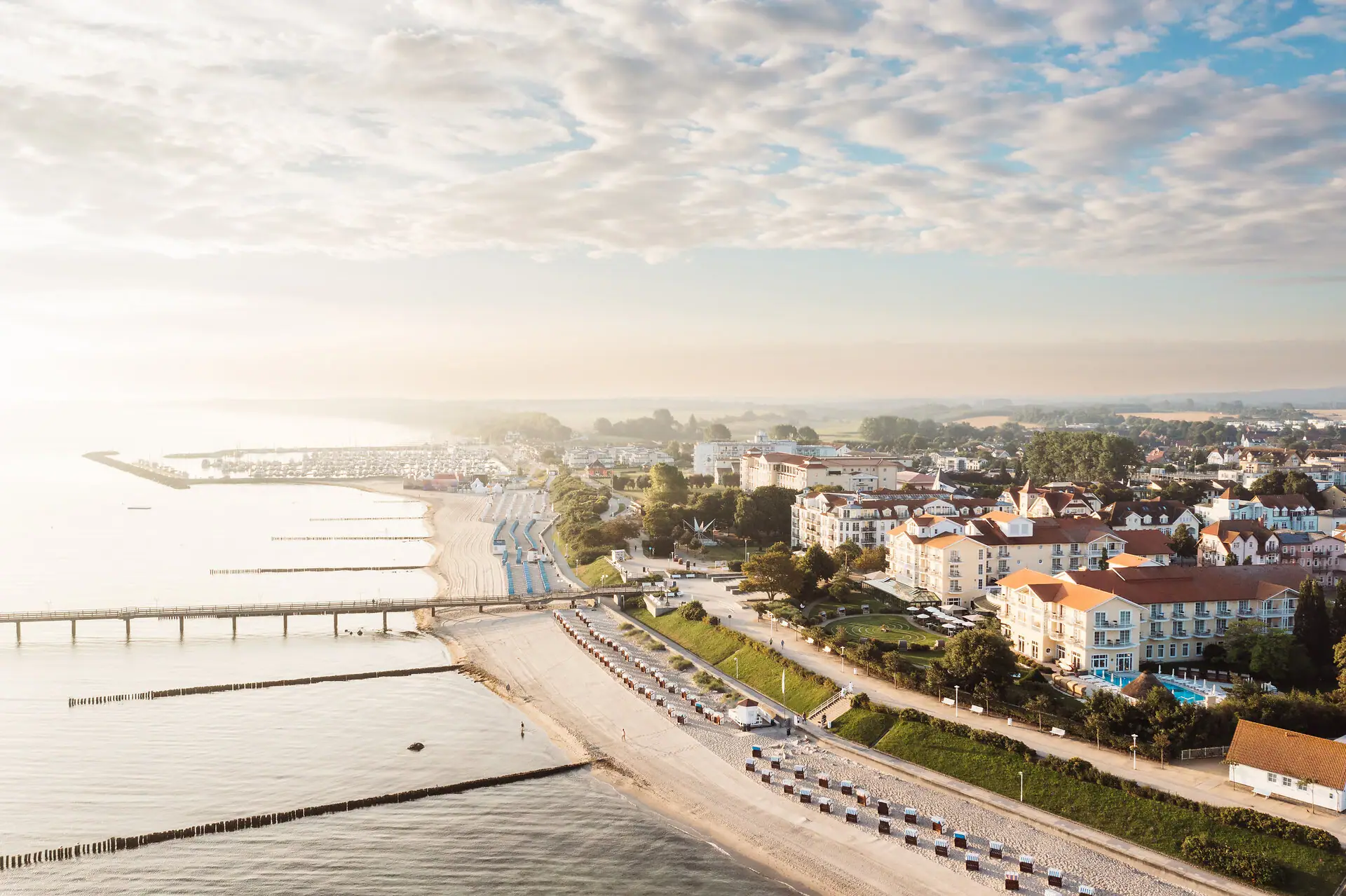 Strand mit Gebäuden und einer Brücke im Hintergrund.