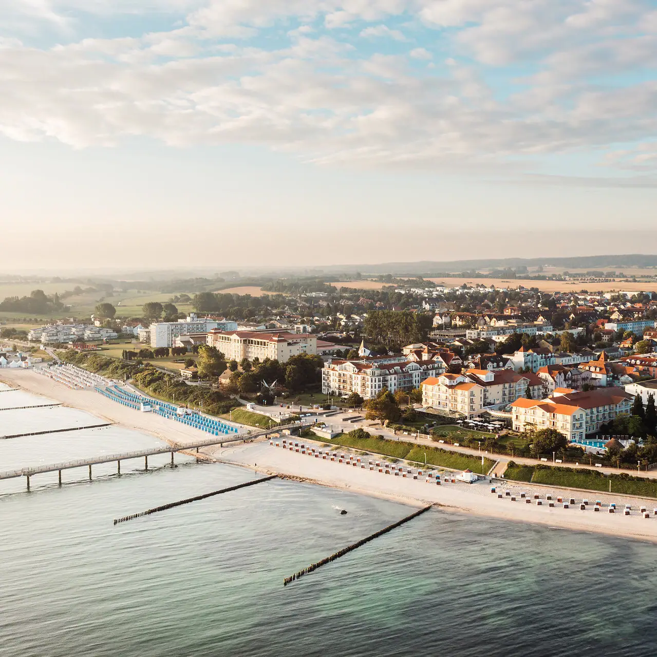 Kühlungsborn Città costiera con edifici e cielo nuvoloso sopra un corpo d'acqua.