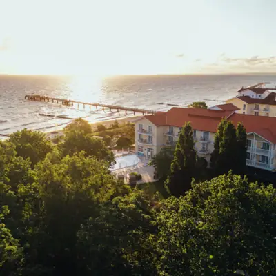 Edificio accanto all'acqua con cielo e alberi sullo sfondo.