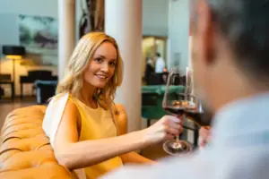 Lifestylebar Frau hält ein Weinglas und lächelt.