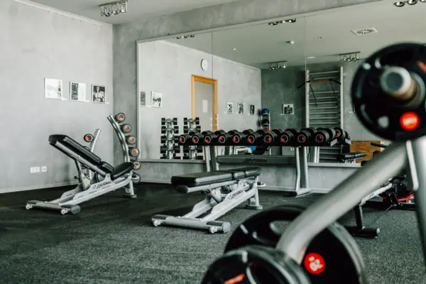 Gewichte und Hanteln Ein Raum mit Hanteln und einem Spiegel.