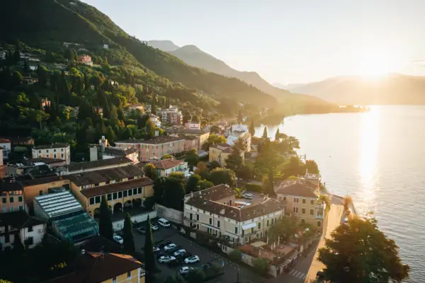 Gardasee Stadt am Wasser mit Bergen und Bäumen im Hintergrund.