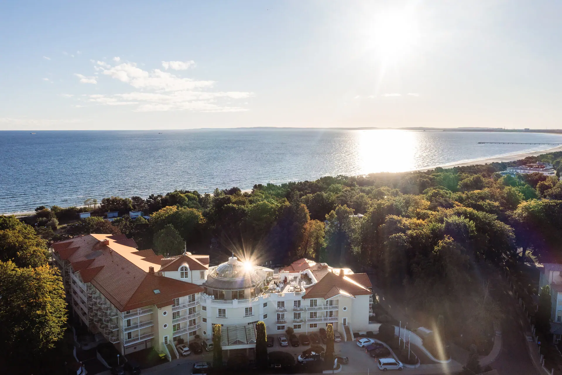 Ein Gebäude mit Bäumen und Wasser im Hintergrund.