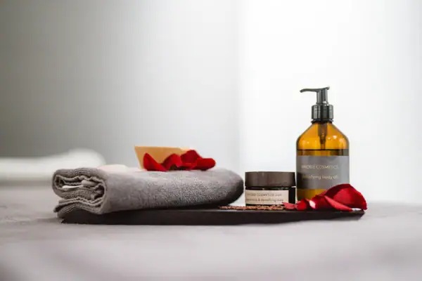 Vinoble deluxe Packages Ein Handtuch neben einer Glasflasche mit Flüssigkeit.