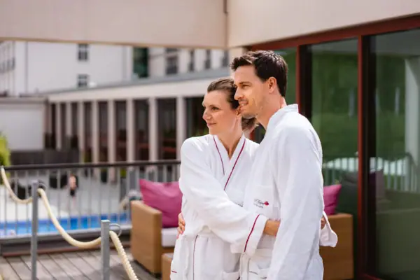 Un uomo e una donna che indossano accappatoi bianchi.