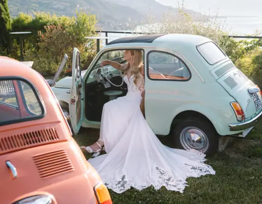 Terrasse 500 im A-ROSA Gardasee Eine Braut mit einem weißen  Hochzeitskleid sitzt in einem Fiat 500.