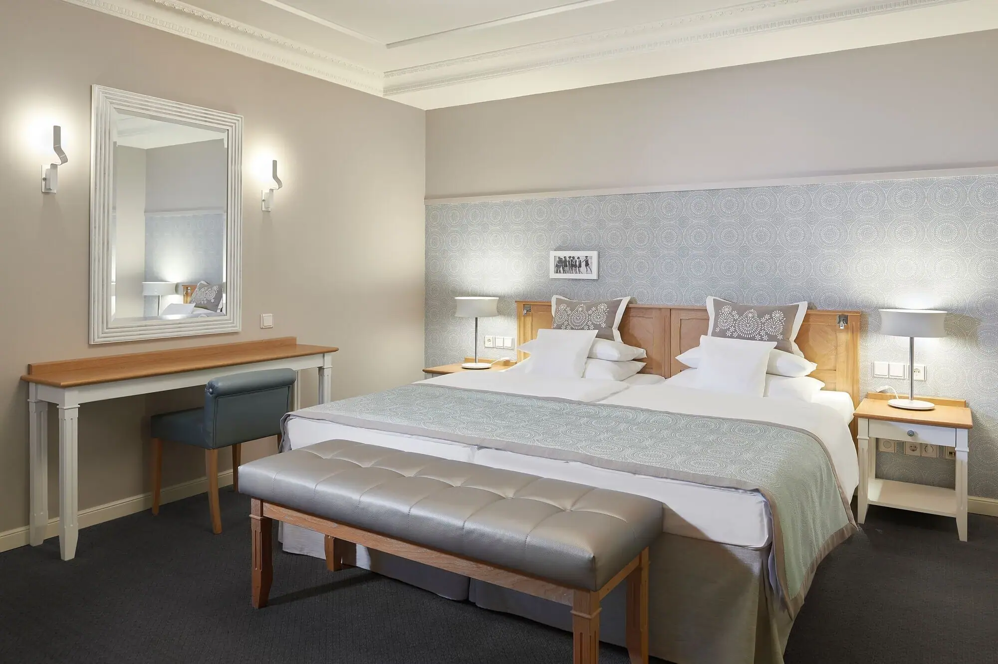 Kurhaus Binz Suite Hotelzimmer mit einem großen gemütlichen Bett und einem Spiegel an der Wand daneben.