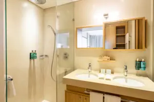 Bagno con doccia e lavabo, dotato di accessori e piastrelle moderne.