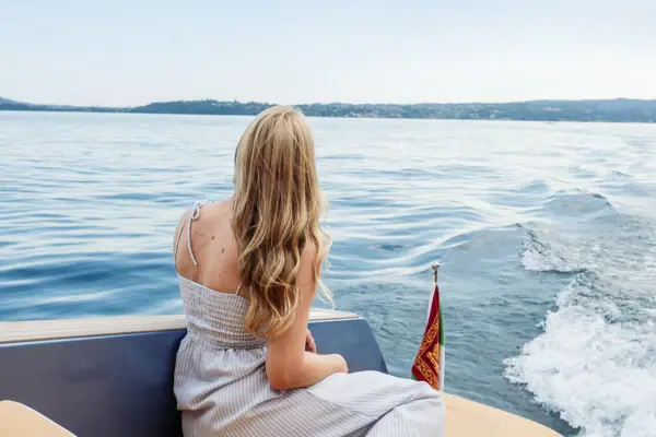 Gita in barca all’Isola del Garda Una donna è seduta su una barca.