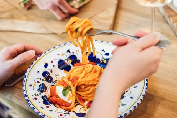 Una persona che mangia del cibo su un piatto.