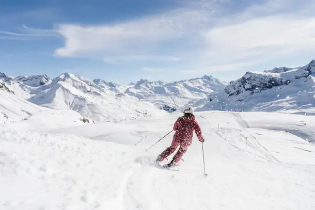 Sciare a Zürs sull’Arlberg Una persona scende con gli sci lungo una montagna innevata.